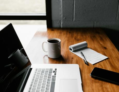 A computer and mug on a table to illustrate writing a great resume