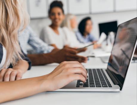 Woman typing on laptop to illustrate choosing the best resume font