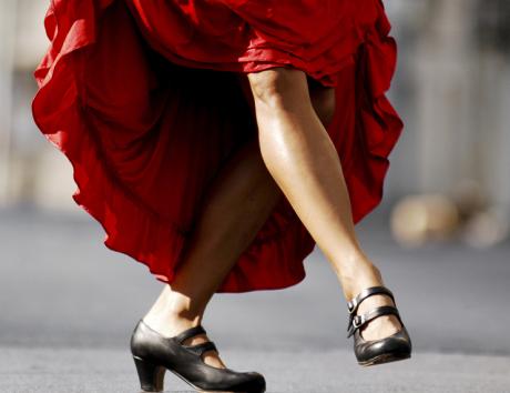 A woman dancing in a red dress to illustrating writing a resume in Spanish