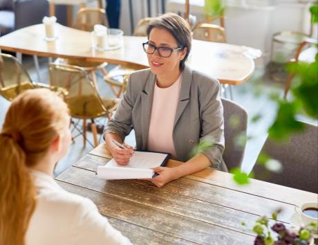 A recruiter speaking to a candidate to illustrate what not to include on a resume